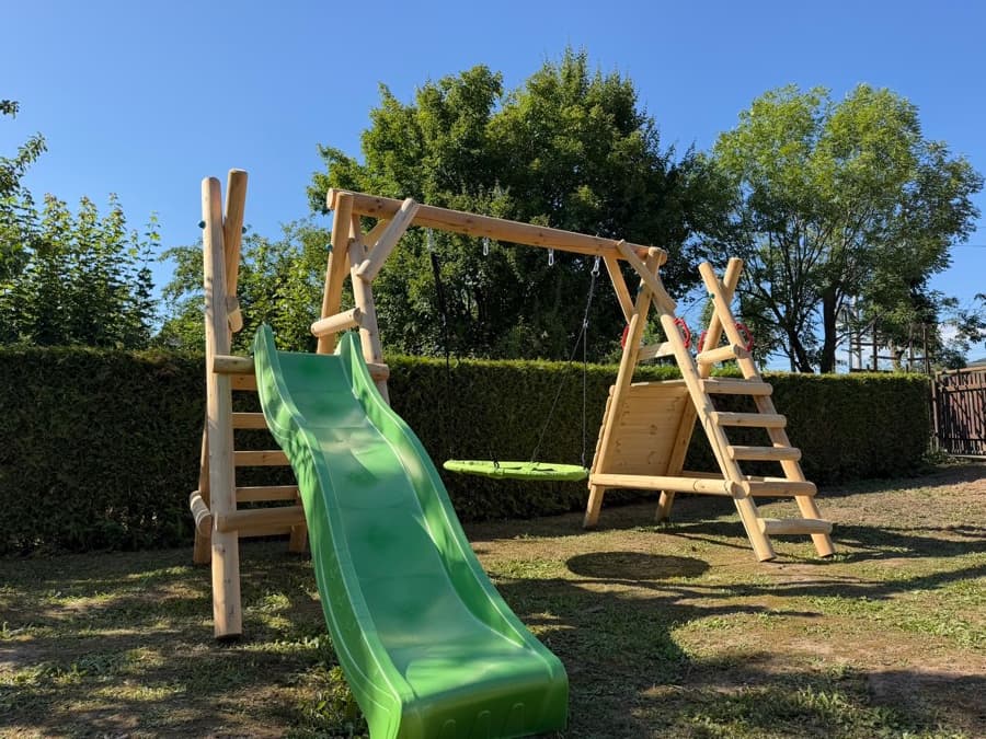 Prolézačka se skluzavkou a houpačkami na zahradě