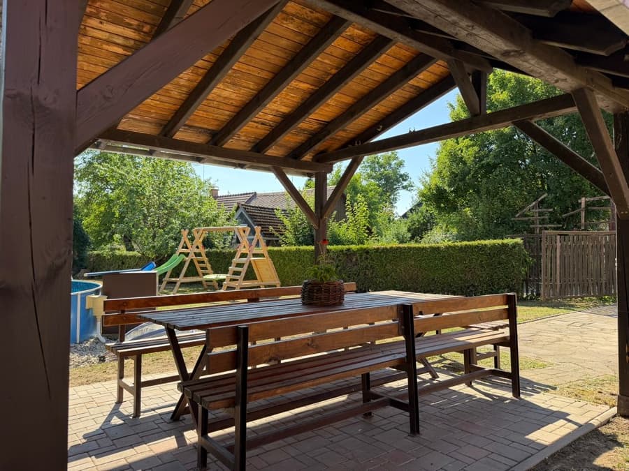 Zastřešená pergola s posezením na zahradě